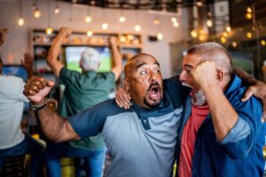 Two fans are pictured here celebrating at a football watch party.