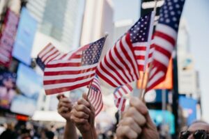 This is a photo shows the hands of parade-goers waving American flags.