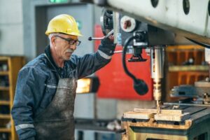 An older worker is pictured here running a machine in a factory.