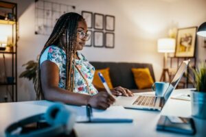 A remote worker sits at her desk and works to complete an online training session.